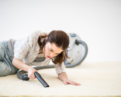 Carpet-Cleaning-Niagara-7-Easy-Ways-to-Keep-Your-Carpets-Looking-Great-woman-down-on-the-floor-vacuuming-the-carpet